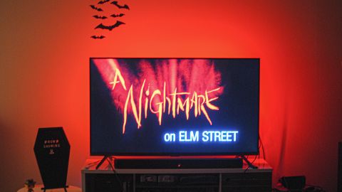 'A Nightmare on Elm Street' movie playing on TV with red lights behind screen.