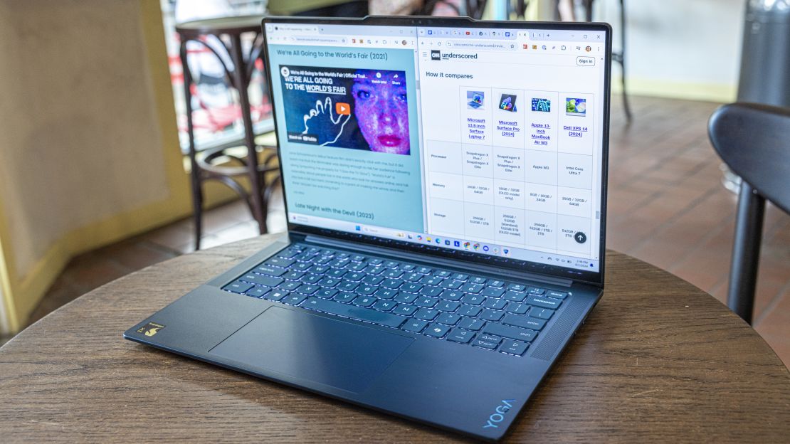 Lenovo yoga slim 7x with window split between an article about a movie and a comparison table of other laptops