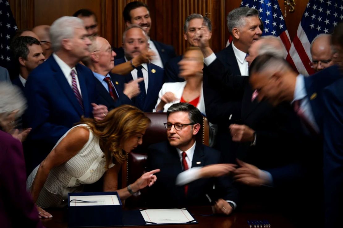Los miembros republicanos del Congreso se acercan para estrechar la mano del presidente de la Cámara de Representantes, Mike Johnson, después de que Johnson firmara el proyecto de ley.
