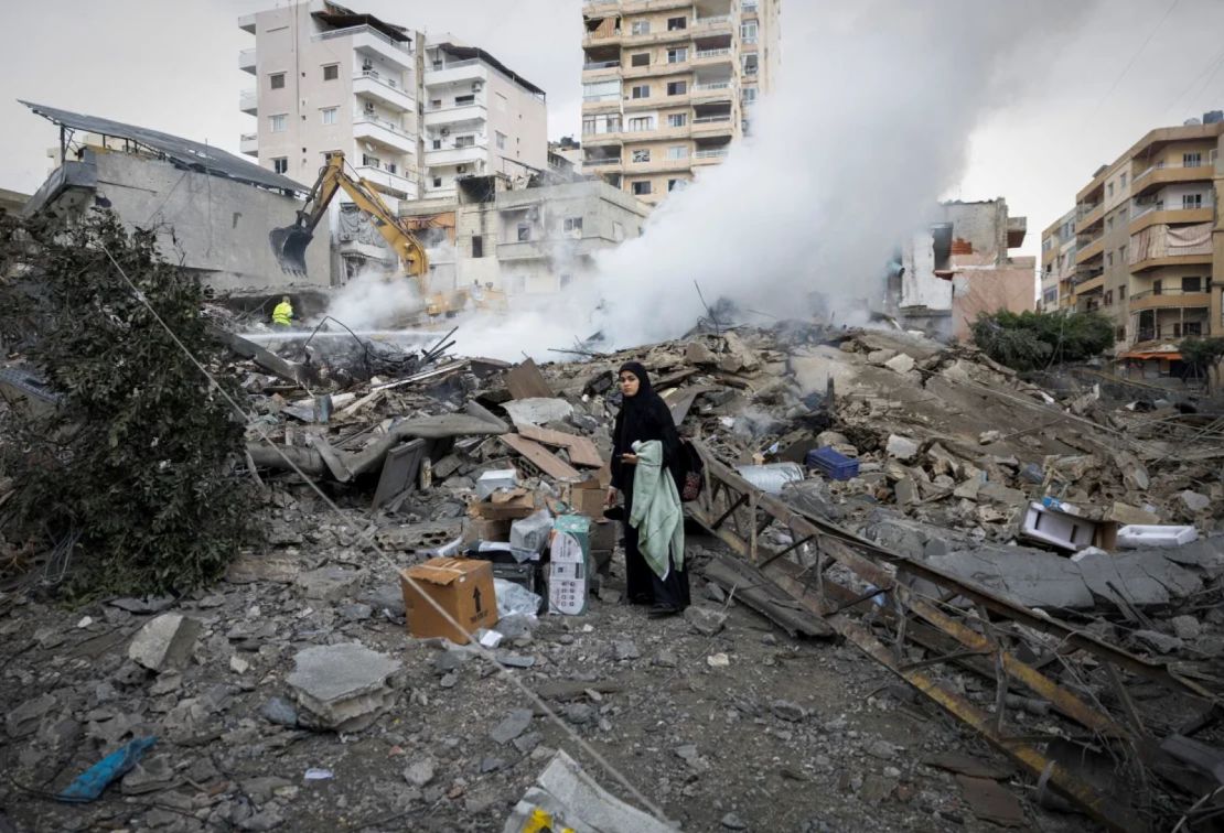 Una mujer busca sus pertenencias entre los escombros de un edificio destruido en la ciudad de Tiro, tras la entrada en vigor de un alto el fuego entre Israel y el grupo respaldado por Irán, Hezbollah, a finales de noviembre de 2024.