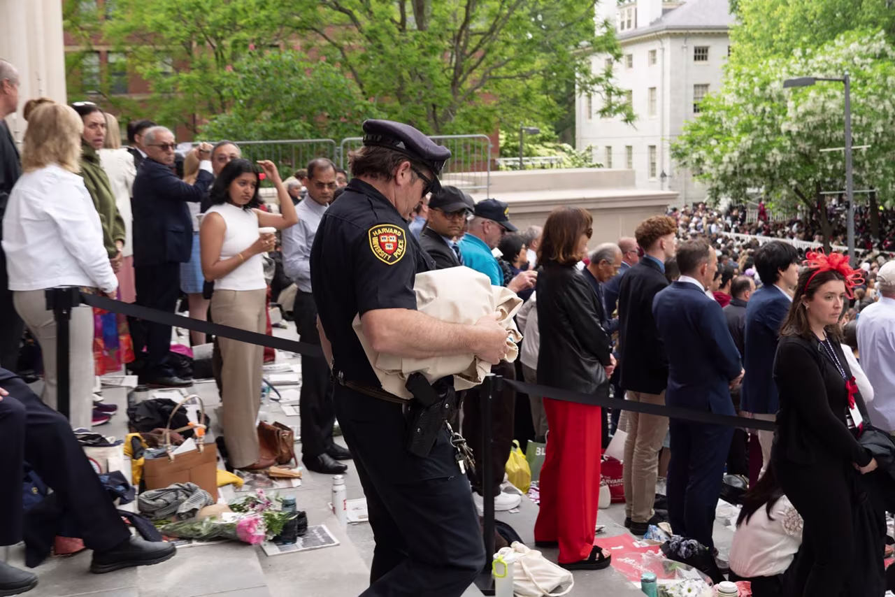 A Harvard police officer is seen holding a confiscated banner on the Widener Library steps.