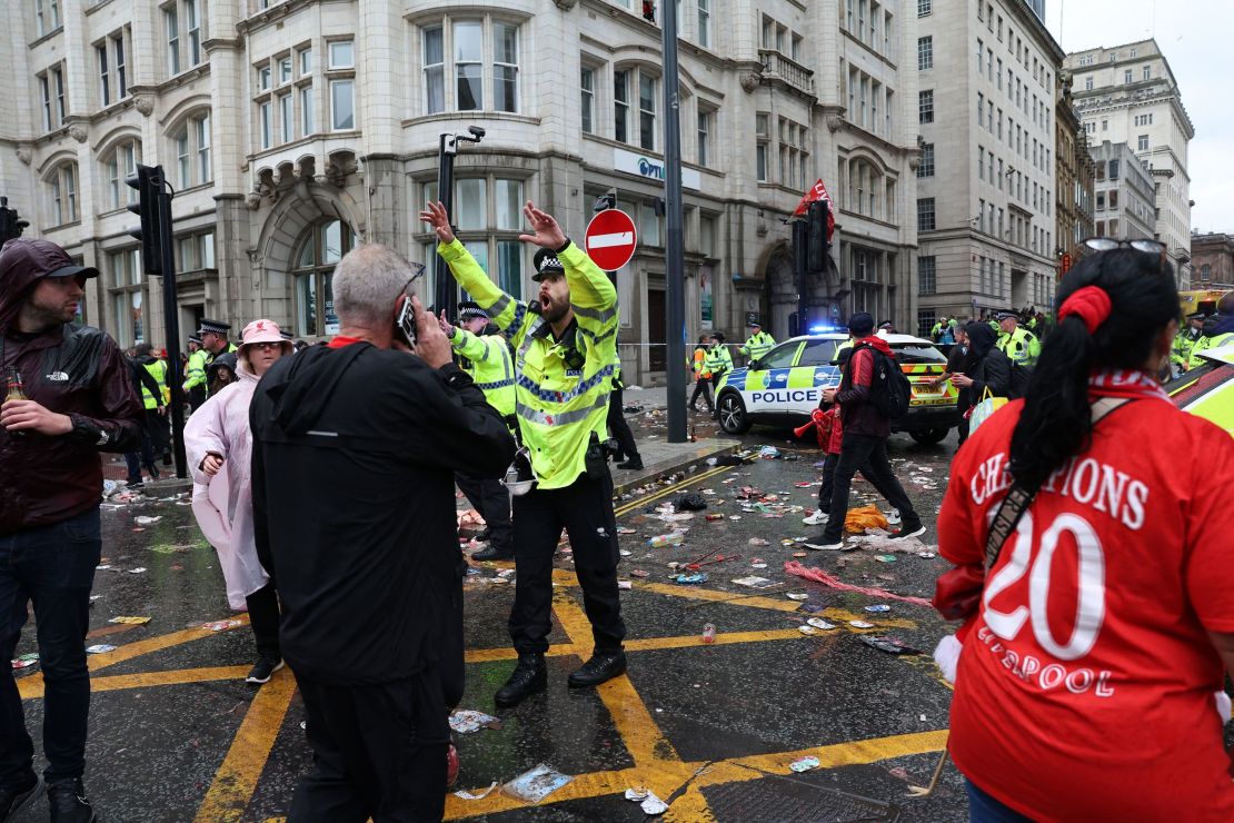 Un oficial de policía grita a los fanáticos del Liverpool mientras está de servicio en un cordón policial a la entrada de Water Street, en la escena de un incidente, al margen de un desfile de la victoria en autobús descapotable por el título de la Premier League de Liverpool, en Liverpool, noroeste de Inglaterra, el 26 de mayo de 2025.