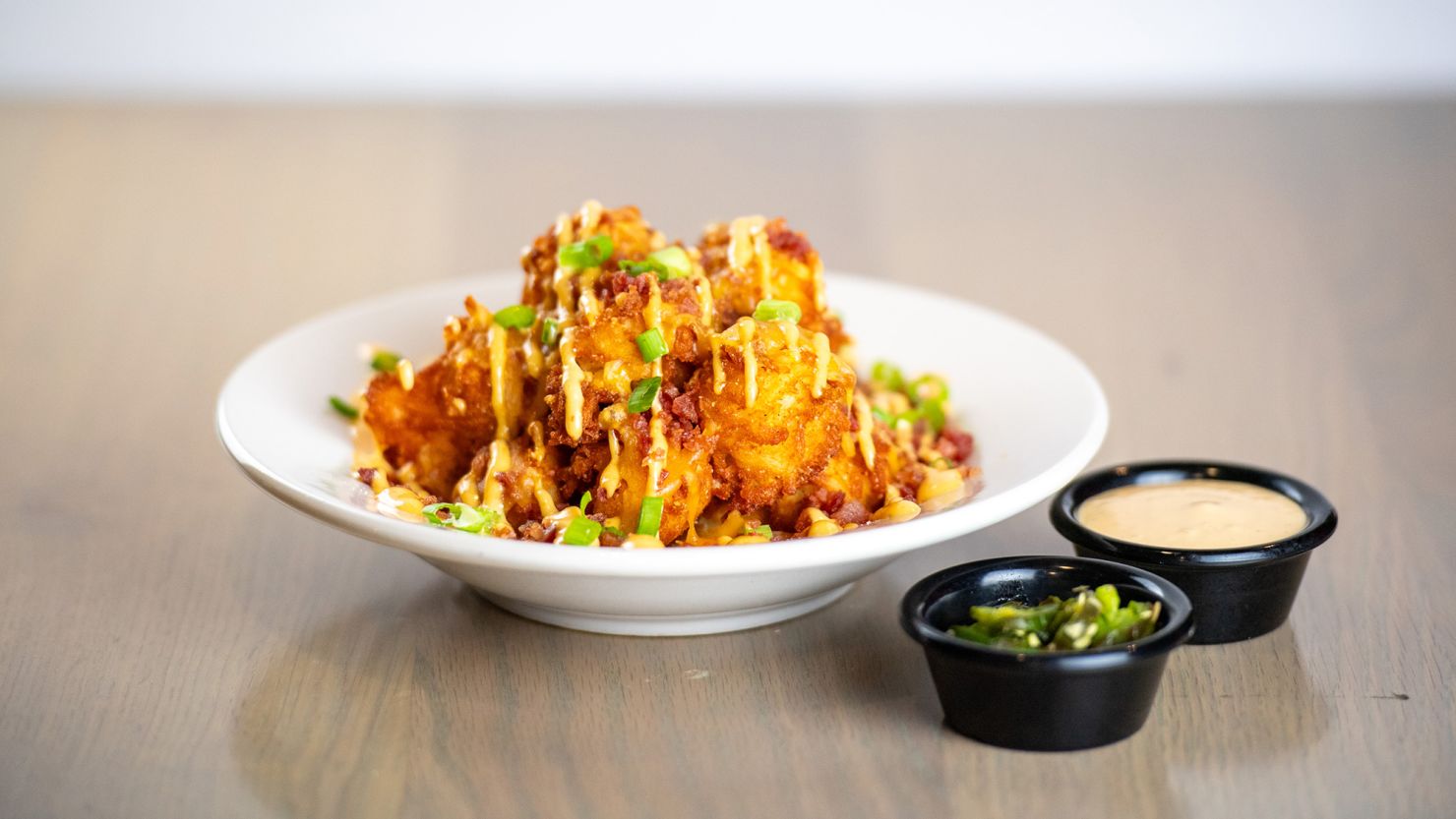 "Loaded Tots," topped with cheese, bacon and green onions is served with "TGI Sauce."