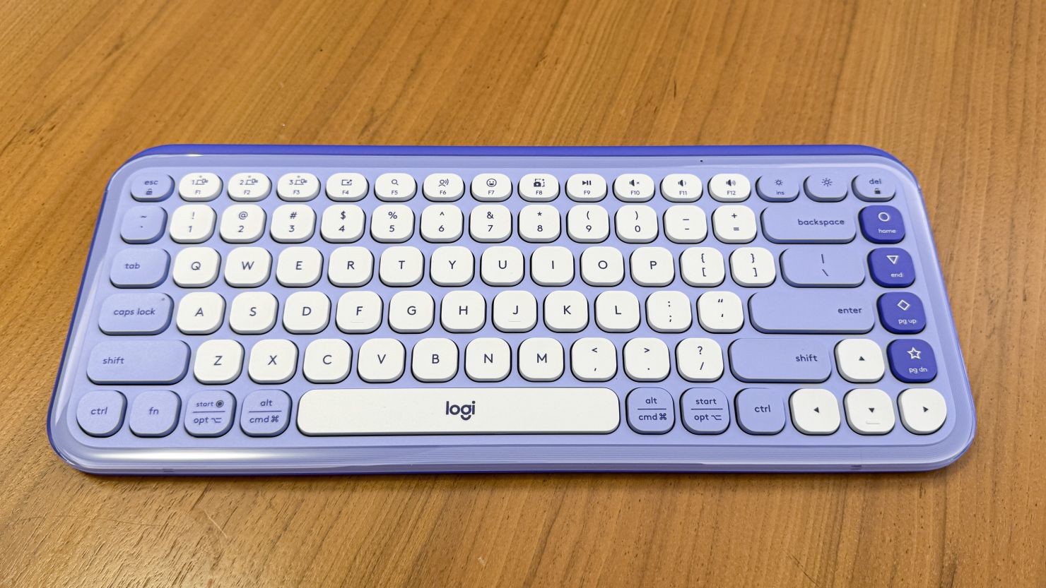 The lilac Logitech Pop Icon Keys keyboard on a wooden table