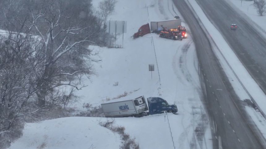 A still from the video shows semi-trucks jackknifed and stuck in the snow in Iowa City, Iowa, on Saturday.