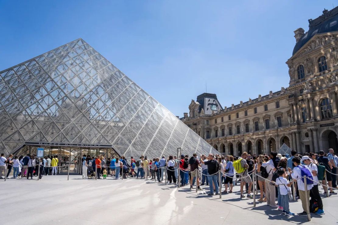 Turistas haciendo cola para entrar en el museo y la pirámide del Louvre en París, Francia, el 7 de junio de 2024.