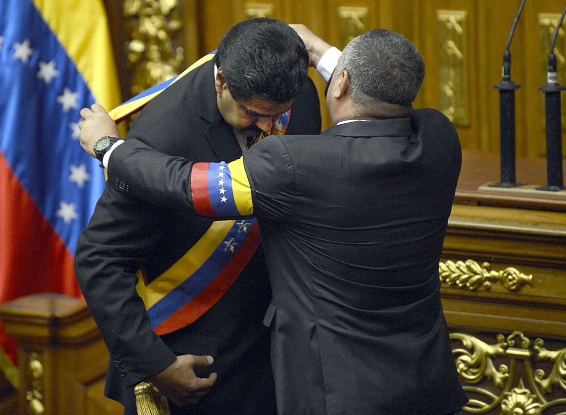 El presidente de la Asamblea Nacional, Diosdado Cabello, pone la banda presidencial al vicepresidente de Venezuela, Nicolás Maduro, después de haber prestado juramento como presidente encargado, en Caracas, el 8 de marzo de 2013.