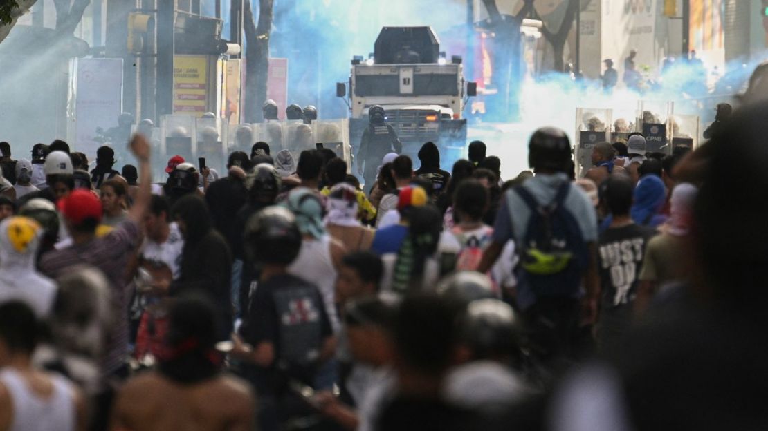 Los manifestantes chocan con la Policía cerca de un vehículo policial blindado durante una protesta contra el presidente de Venezuela, Nicolás Maduro, en Caracas, el 29 de julio de 2024, un día después de las elecciones presidenciales.