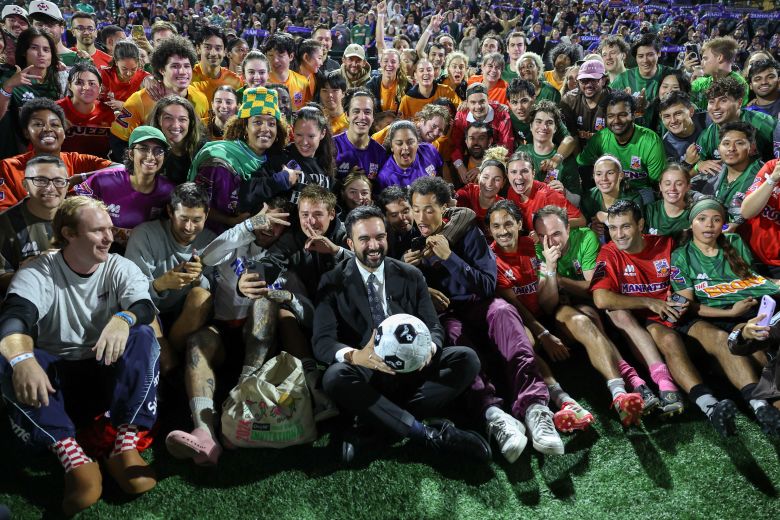 Mamdani, 19 Ekim'de New York'ta düzenlenen "Yaşamın Maliyeti Klasik" futbol turnuvasına katılanlarla birlikte grup fotoğrafı çektiriyor.