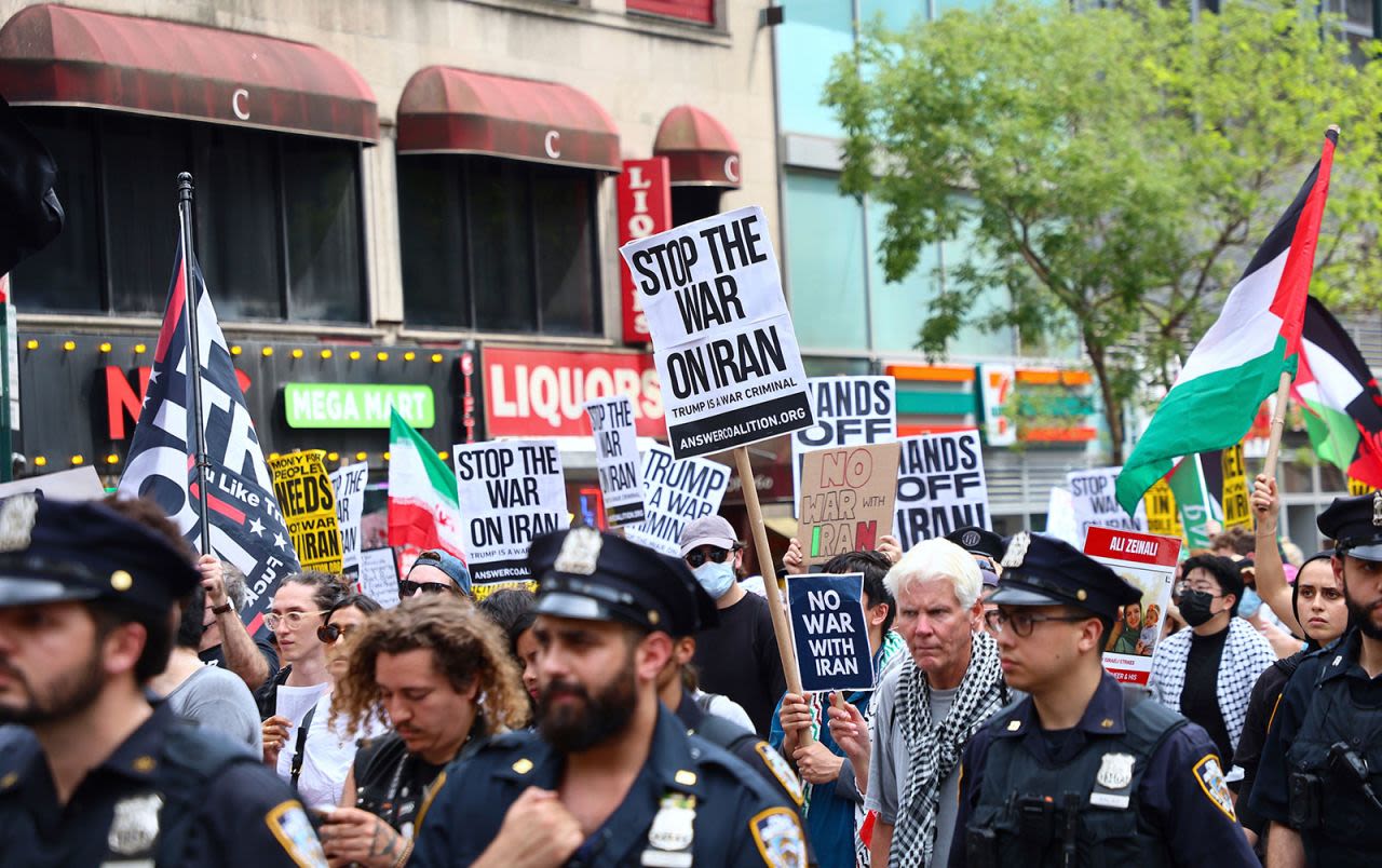 La gente sostiene carteles mientras se manifiesta y marcha contra los ataques estadounidenses a los sitios nucleares iraníes y a la iniciativa Palestina Libre, desde Times Square hasta Columbus Circle en Nueva York el 22 de junio de 2025