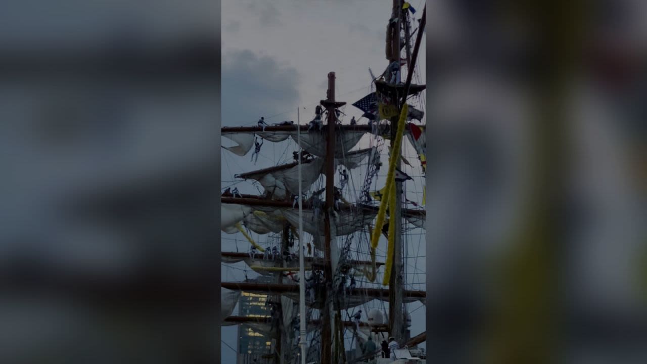 Esta captura de pantalla, extraída de un video, parece mostrar a personas colgando del mástil del barco poco después de que impactara contra el puente de Brooklyn. Más de una docena de personas resultaron heridas y, aunque no se reportan desaparecidos, dos personas murieron, según el alcalde de la ciudad de Nueva York, Eric Adams.