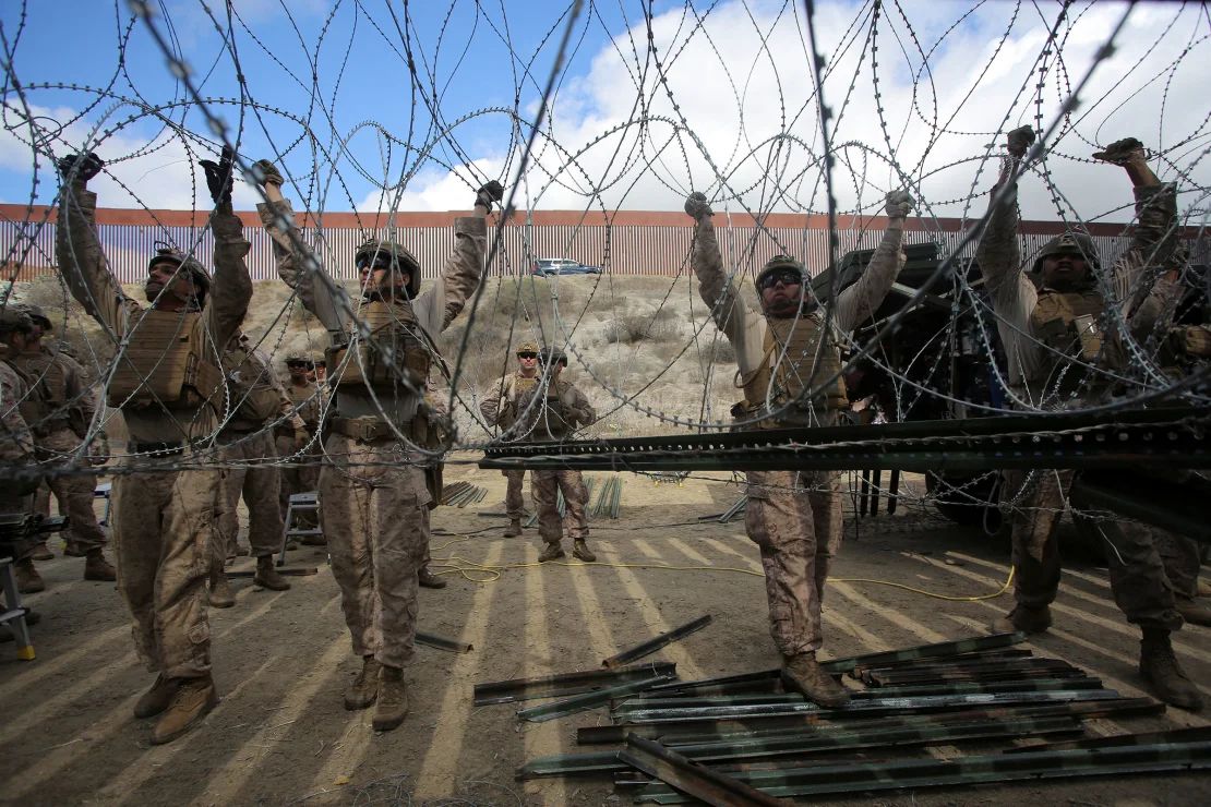 Marines estadounidenses ajustan alambre de concertina a lo largo de la frontera entre México y Estados Unidos, visto desde Tijuana, México, el 6 de febrero.