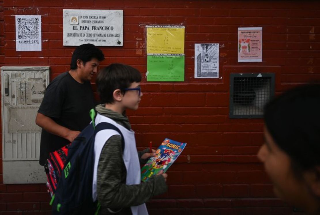 Un estudiante pasa junto a una placa conmemorativa frente a la escuela donde estudió el difunto papa Francisco en Flores, un barrio obrero de la capital.