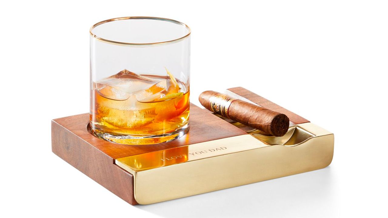 Whiskey and cigar displayed on wood tray