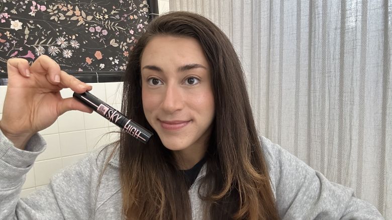 Carolina holding a tube of Maybelline Sky High Mascara. 