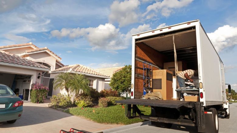 A moving truck arrives at a house and begins to be unloaded.