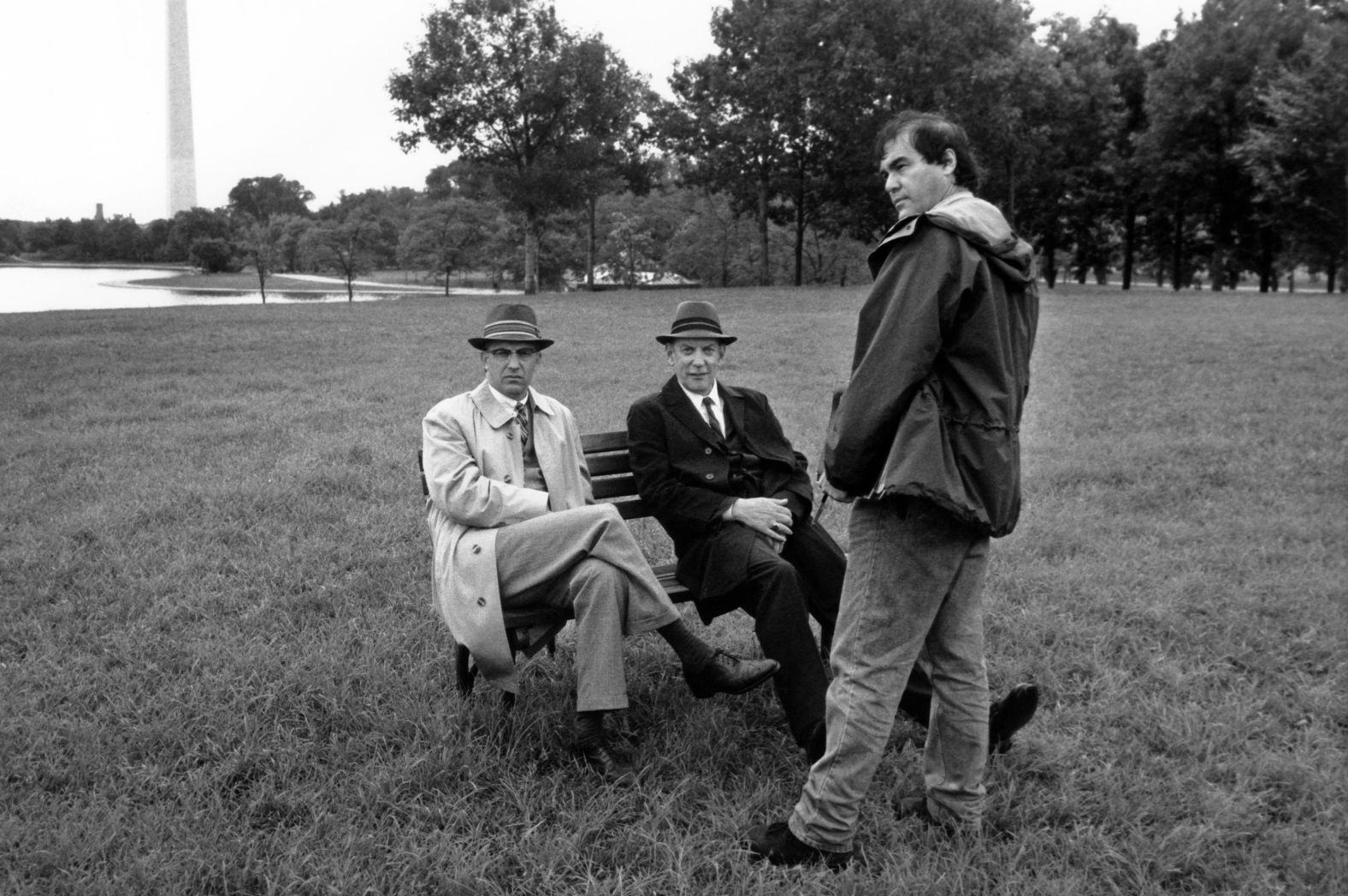 From left, actor Kevin Costner, Sutherland and director Oliver Stone talk on the set of “JFK” in Washington, DC, in 1991.