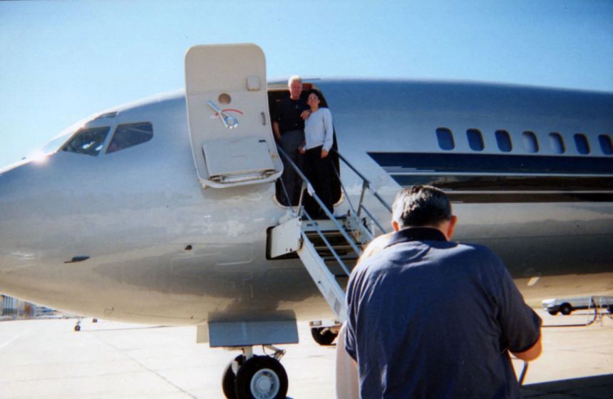 Former President Bill Clinton poses alongside Ghislaine Maxwell on Jeffrey Epstein's private jet.