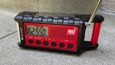 A Midland ER310 emergency weather radio on a concrete step, outdoors