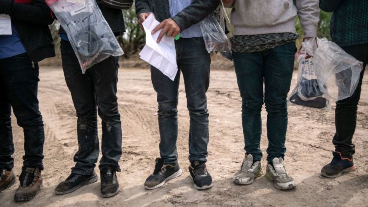 Menores no acompañados esperan el transporte de la Patrulla Fronteriza después de cruzar el río Bravo hacia Hidalgo, Texas, el 25 de marzo de 2021.