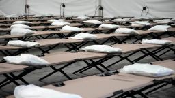 Bolsas con ropa de cama se colocan en catres dentro de la tienda del dormitorio durante un recorrido por un refugio que la ciudad de Nueva York está preparando para albergar hasta 1.000 migrantes, en el distrito de Queens de Nueva York en agosto de 2023.