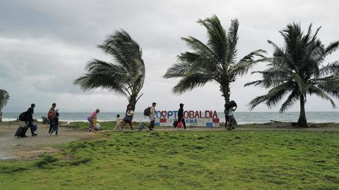 Migrantes venezolanos caminan en la ciudad de Puerto Obaldía, Panamá, a menos de 5 kilómetros de la frontera con Colombia, durante su viaje de regreso a Venezuela el 15 de abril de 2025.
