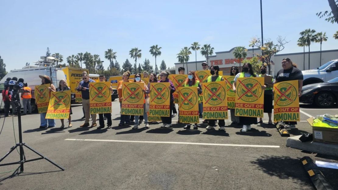 Defensores de los jornaleros sostienen carteles después de una redada cerca de un Home Depot en Pomona, California, el 22 de abril.
