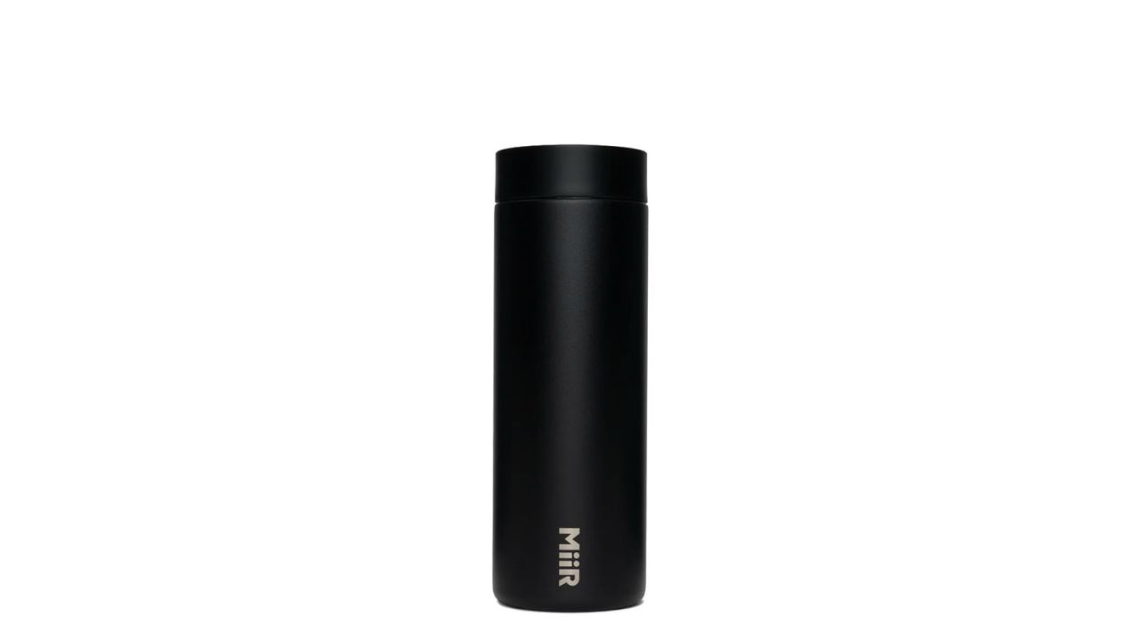 Black travel mug placed against white background.