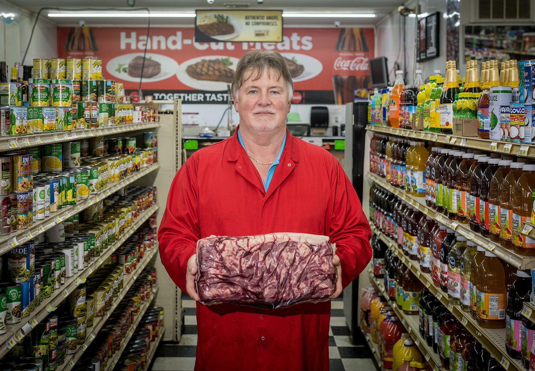 Mike Moatts, o açougueiro da Elberta Grocery em Elberta, Alabama, que também serve comida indiana às segundas-feiras – cortesia de um de seus caixas, Dhinal Patel.