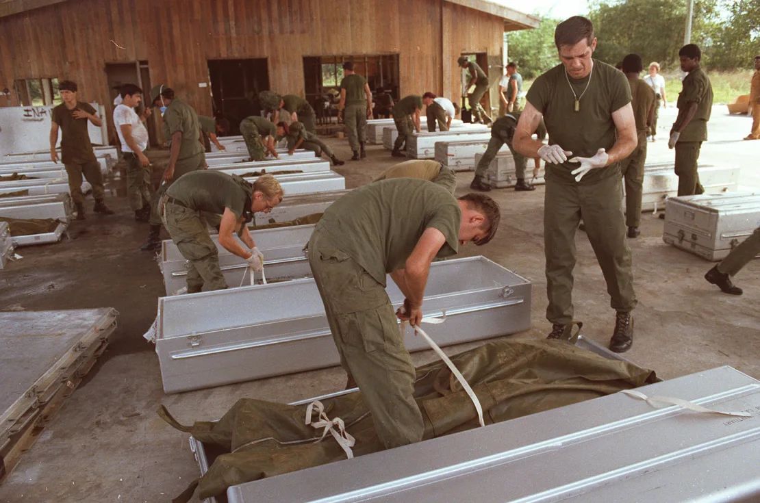 Personal militar estadounidense coloca cuerpos en ataúdes en el aeropuerto de Georgetown, Guyana, en noviembre de 1978.