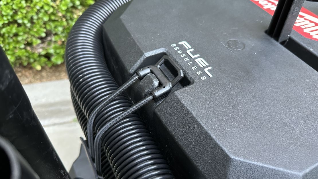 A bungee attachment on the Milwaukee vac helps keep excess hose length out of the way.