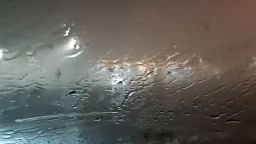Video is filmed from the interior of a car with rain and heavy winds seen and heard outside. In the car is Tad Peters with a co-passenger describing the scene as the tornado hits.