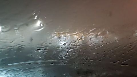 Video is filmed from the interior of a car with rain and heavy winds seen and heard outside. In the car is Tad Peters with a co-passenger describing the scene as the tornado hits.