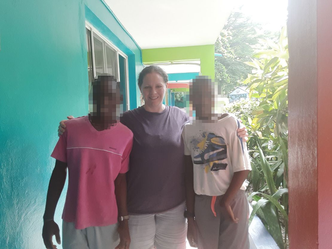 Missy Tennant is seen in an undated photo with the<strong> </strong>two children from Haiti who are now stuck at an orphanage there. CNN blurred the faces of the children to protect their identity.