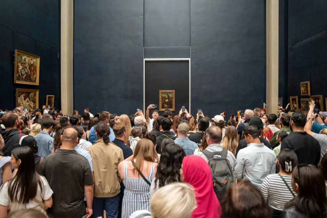 Multitud de turistas con sus teléfonos en la mano, tomando fotos de la Mona Lisa de Leonardo da Vinci en el interior del Museo del Louvre en París, Francia, el 7 de junio de 2024