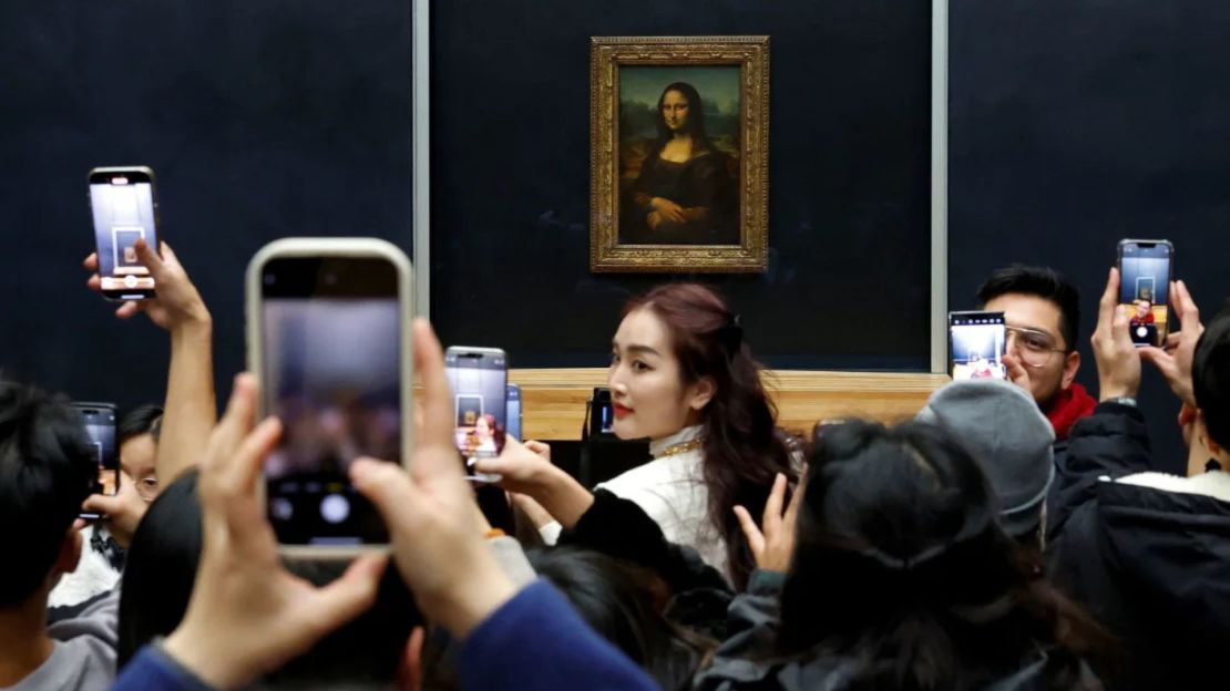 Los visitantes toman fotos de la "Mona Lisa" en el Louvre el jueves.