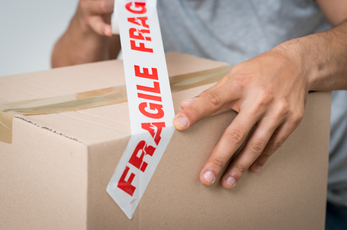 Man wraps box in fragile tape