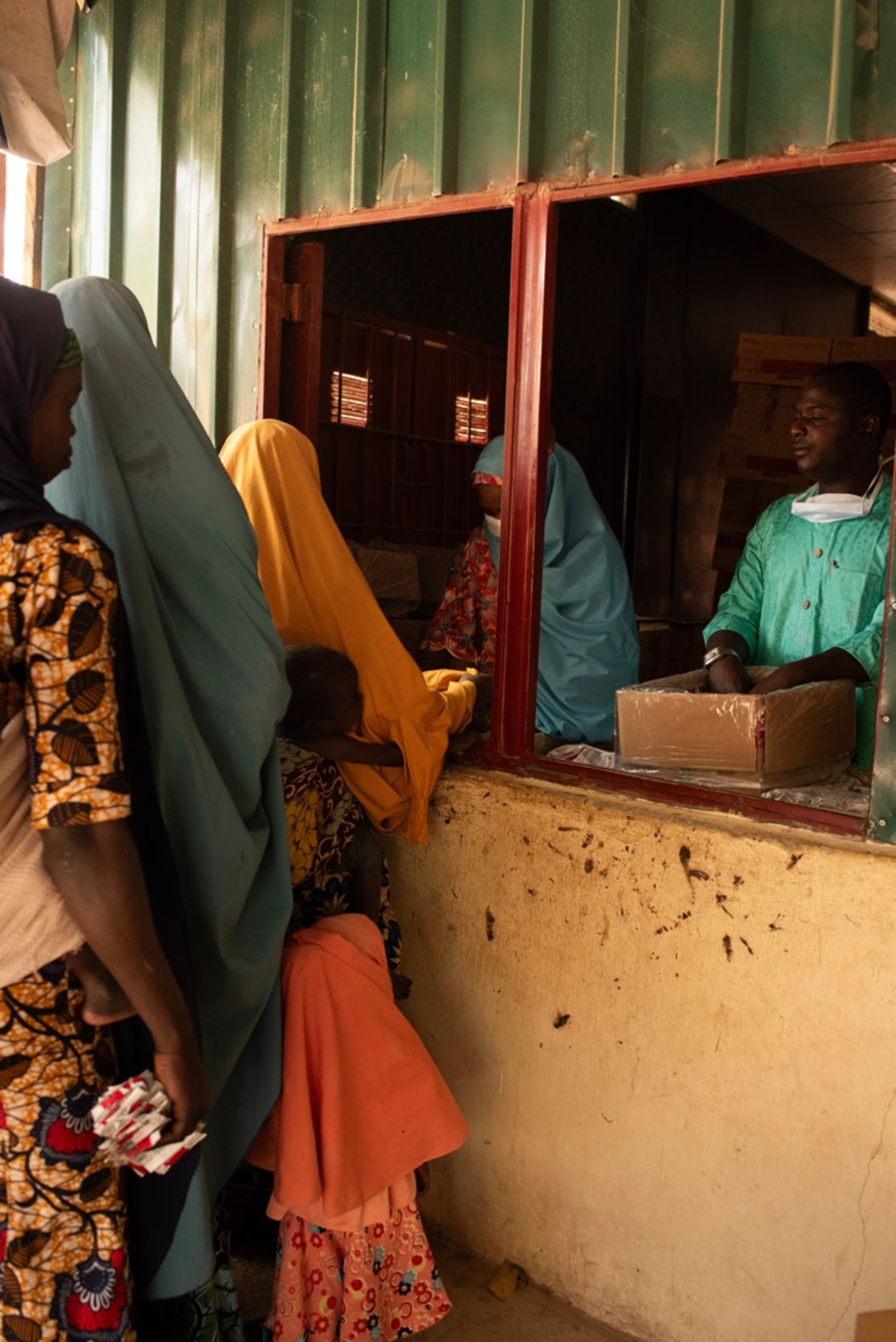 Pharmacy workers distribute sachets of Ready To Use Therapeutic Food (RUTF) called Plumpy'Nut to mothers in northwest Nigeria.