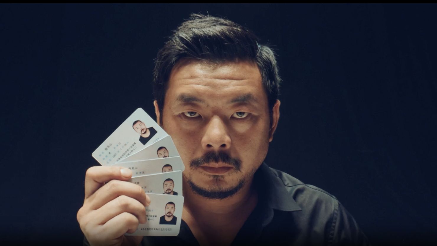An actor playing a spy shows off his multiple identity cards in a propaganda video released by China's Ministry of State Security to warn the public about foreign spies.
