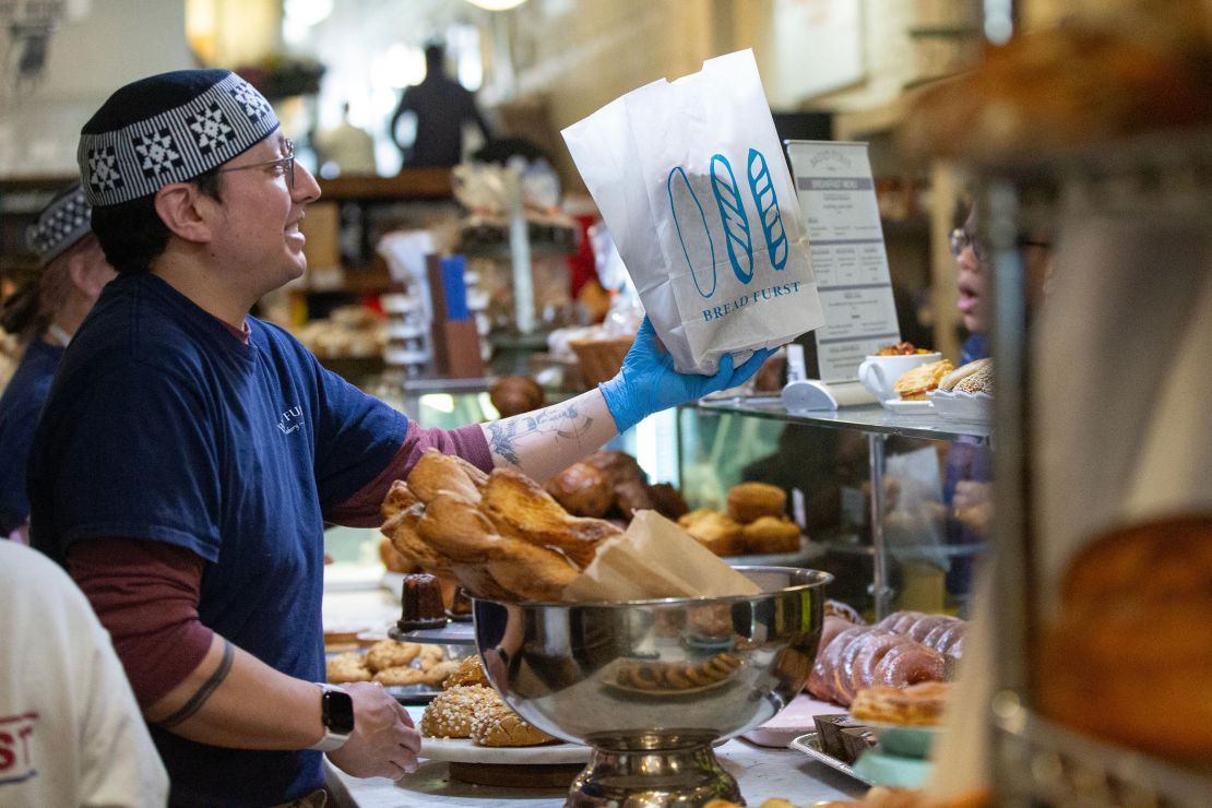 An employee hands out a bag of pastries at Bread Furst in Washington, DC, on Saturday.