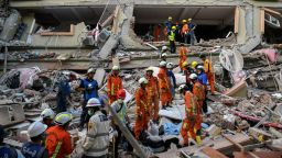 Los equipos de rescate trabajan para evacuar a los residentes atrapados bajo los escombros de un edificio derrumbado en Mandalay, Myanmar, el domingo.