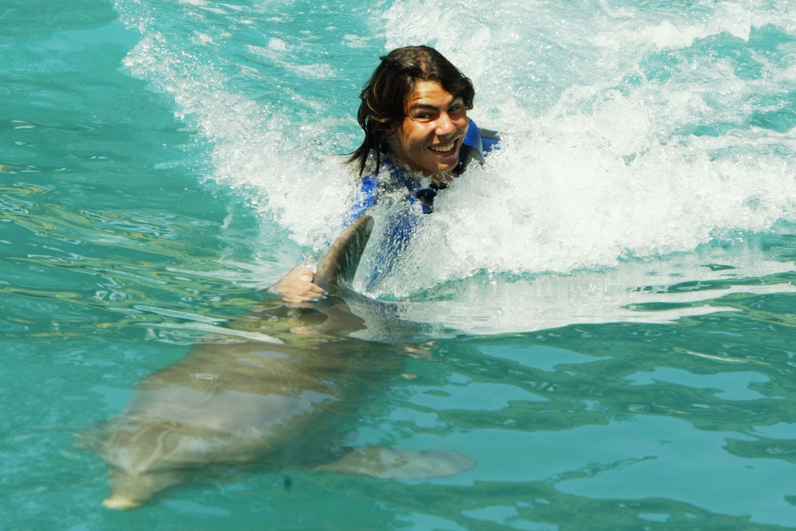 Nadal rides a dolphin at the Miami Seaquarium in March 2004.