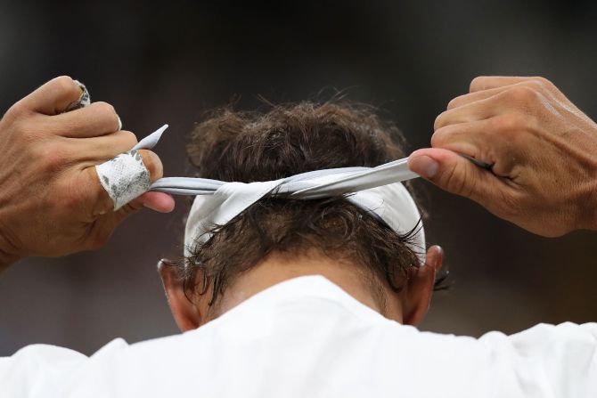 Nadal ties his headband before a Wimbledon semifinal match in 2018.