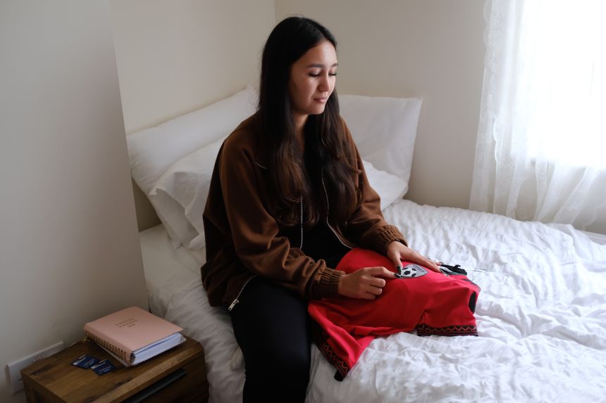 Narges Mayeli sits in her bedroom with an Afghan jersey gifted to her by former coach Khalida Popal.