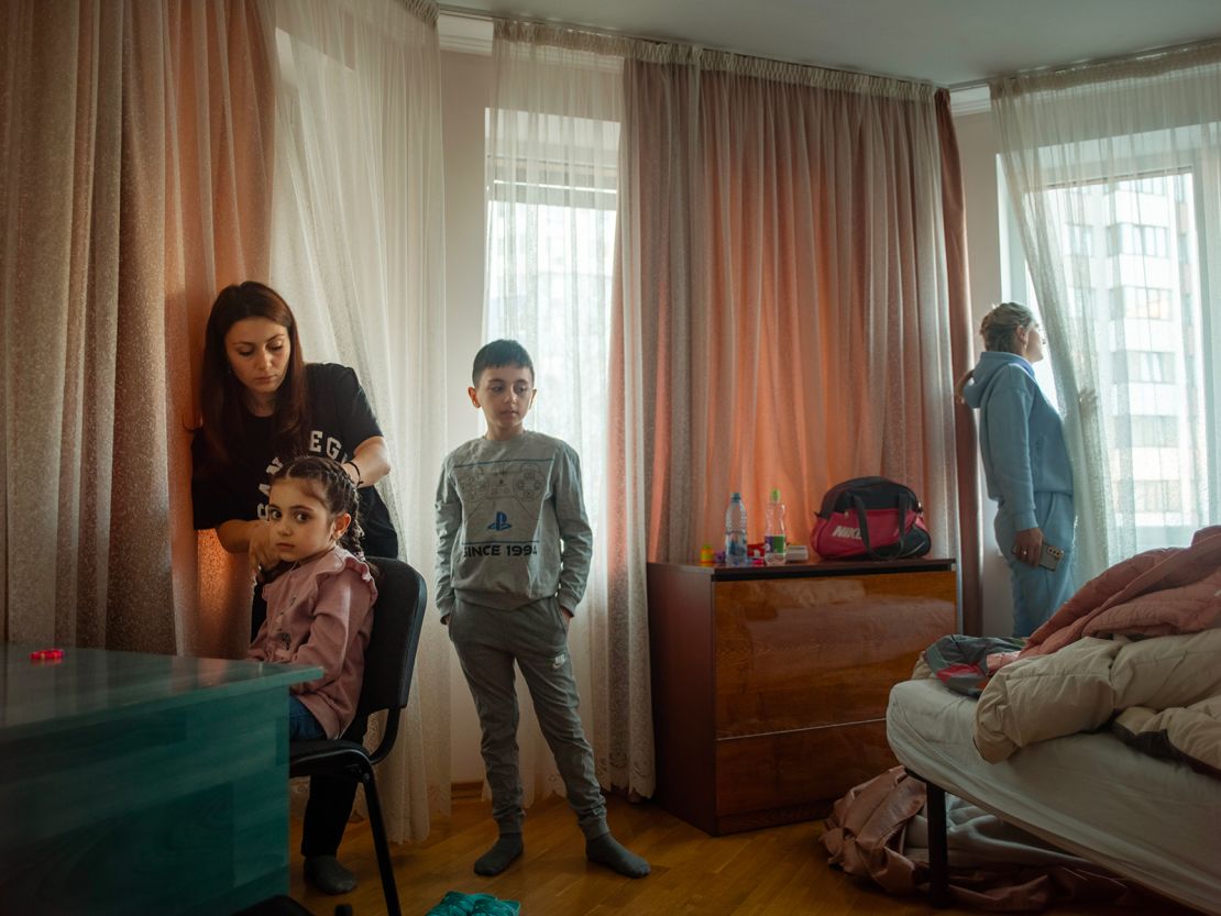 Narine with her children Nicole (6) and Valentine (9). The family were preparing to leave Regina Pacis, Moldova, with their friend Yuliia looking out for a minibus that will drive them to Italy. March 2022.