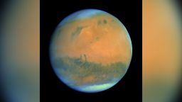 The stunning image of Mars featured here shows off the Red Planet’s renowned colour from the viewpoint of ESA’s Rosetta mission as it flew past on 24 February 2007, en route to Comet 67P/Churyumov-Gerasimenko. It is a composite image created by combining near-infrared, green and near-ultraviolet colour information obtained by the OSIRIS Narrow Angle Camera. The polar ice cap at the south pole is particularly bright, and wispy clouds are seen most clearly around the planet’s curved horizons.