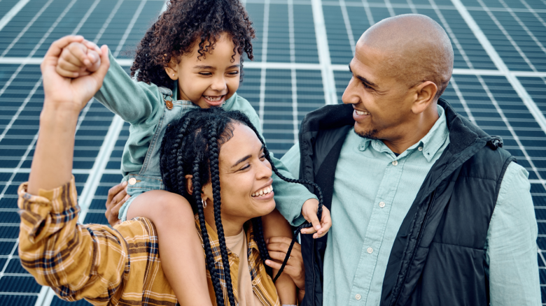 Family with solar panels in the background