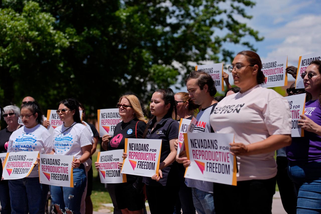 People hold signs during a news conference by Nevadans for Reproductive Freedom, Monday, May 20, 2024, in Las Vegas. 