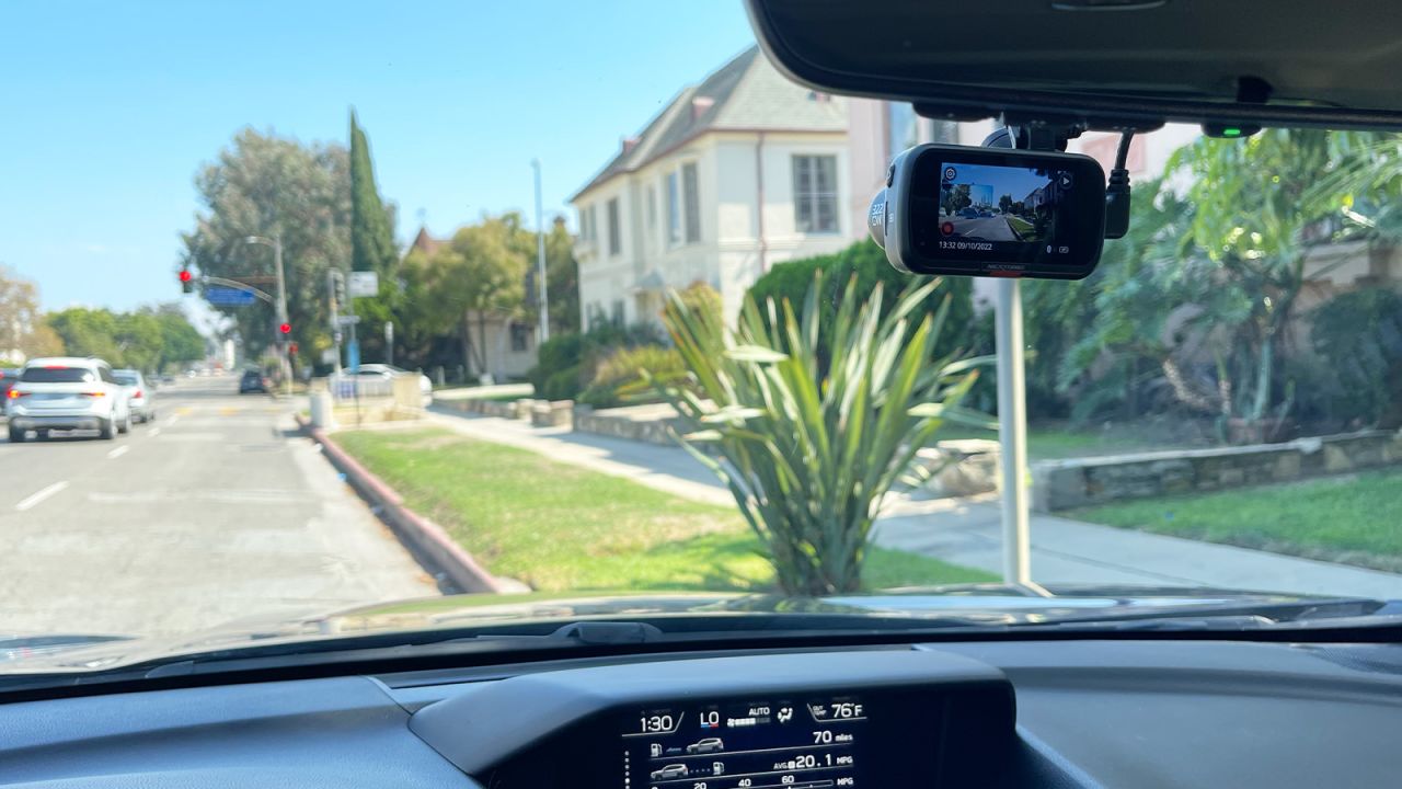 A nextbase 322 camera mounted on a car windshield, with the screen displaying setup menu information