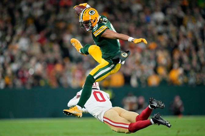 Green Bay Packers wide receiver Christian Watson leaps over San Francisco 49ers cornerback Renardo Green at Lambeau Field in Green Bay, Wisconsin, on November 24. The Packers won 38-10.